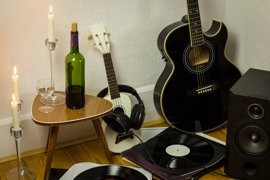Rock'n'roll setup with ukulele, acoustic guitar, speaker, candle