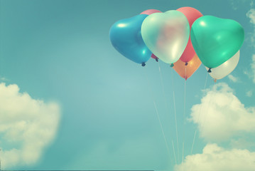 The colorful heart-shaped balloons with blue sky background in vintage style, concept of love in summer and valentine, wedding