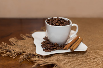 coffee beans and cinnamon white cup and saucer on a table brown texture units large lot of grain