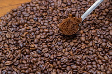 coffee beans and metal spoon on a table brown metal texture close a lot of ground grain
