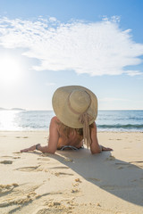 Thoughtful attractive woman bikini sitting on the beach