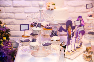 Candy bar. Table with sweet 
candies, purple light at background