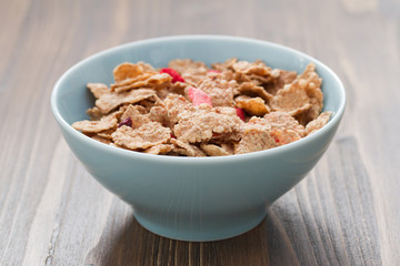 cereals in blue bowl on brown wooden background