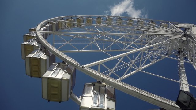Big Wheel in a Theme Park, tilt - 60fps. The Fete foraine du Jardin des Tuileries is a small amusement park that is set up every summer in the Tuileries Gardens in Paris