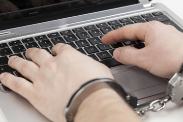 Am Laptop mit Handschellen