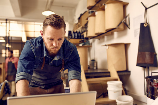 Hipster Business Owner Working On Laptop In His Modern Work 