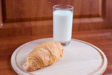 Breakfast with milk and croissant on a wooden table