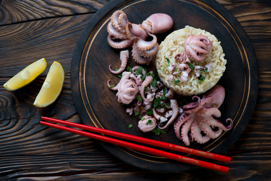 Top view of octopuses with rice on a rustic wooden cutting board