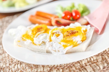 bread with scrambled eggs in white plate.