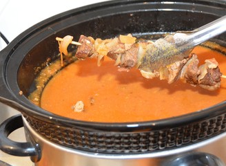 shashlik skewer getting placed into a slow cooker