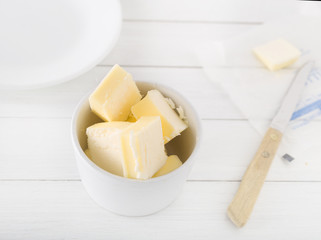 chopped butter in a white bowl on light background
