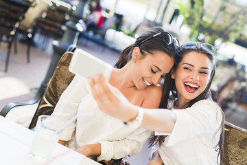 Two young beautiful women taking a selfie of themselves