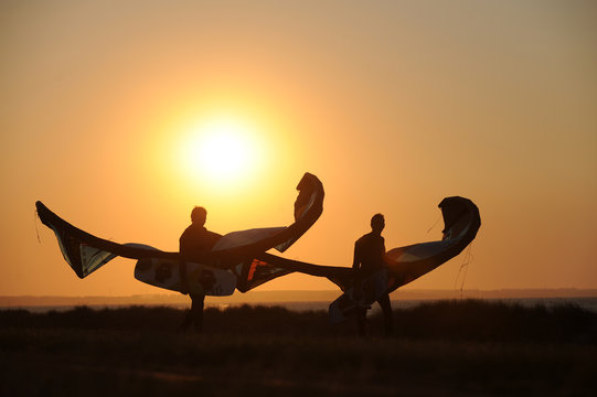zwei kiter tragen ihre kite s in der Abendsonne