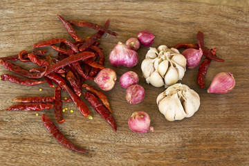 Pepper, garlic and red onion on wood background