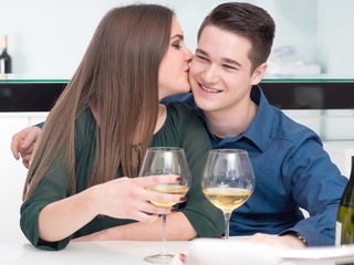 Happy Young Couple Enjoying Wine While Working In Kitchen