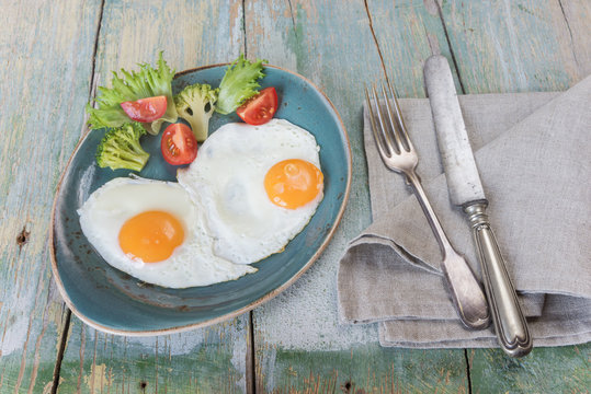 Two fried eggs and vegetables