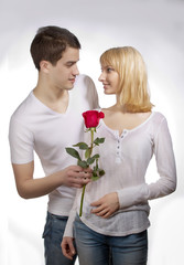 young couple of lovers. Man presents red rose for Valentine day.