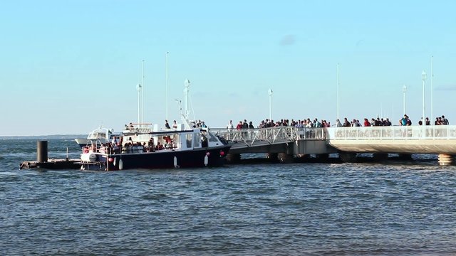 Ferry docking and boarding people, France. Ferryboat arrive at the pier. Boarding anonymous people - 1080p. Arcachon, France
