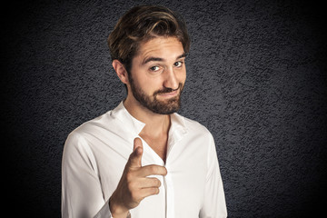Attractive young bearded man pointing at camera