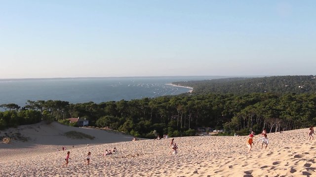 Famous Famous Dune du Pilat top view landscape, France - 1080p. Dune view with forest and ocean with Kids playing around. Shot at the great dune of Pyla (France). Full HD