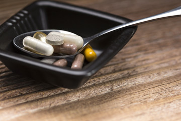Drugs in a small plate on wooden background