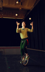 Boy juggling and riding unicycle