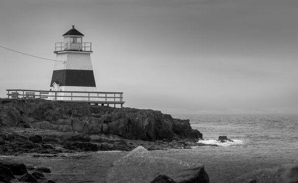 Lighthouse in Margaretsville, Nova Scotia.  Overcast spring day in the Bay of Fundy.  A lone lighthouse atop an outcropping of rock in the Bay on an grey sky, late spring day in Nova Scotia.