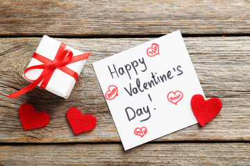 Red heart and sheet of paper on a grey wooden table