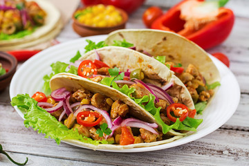 Mexican tacos with meat, corn and olives on wooden background.