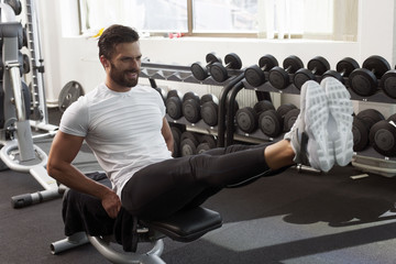 Man in gym, leg raise, abdominal muscles