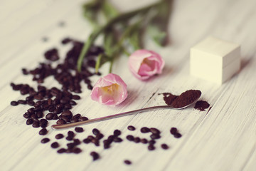 coffee beans, tulip flower and a box for an engagement ring lie on the table