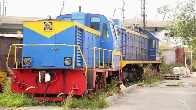 Abandoned bright vintage railway carriage stays on a ground in the depot