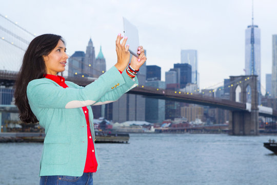 Mixed race woman taking pictures at waterfront, New York, New York, United States