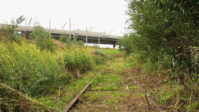 View of an abandoned old railways in summer windy day.Motorway on a background.