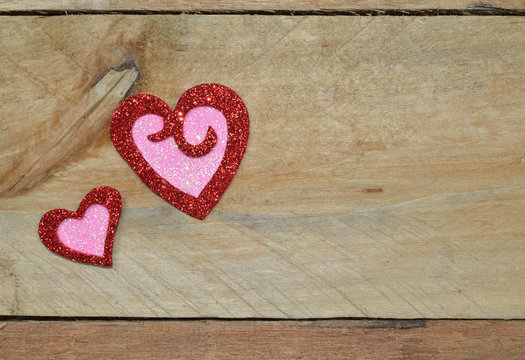 Glittering sparkle of red and pink hearts on pallet wood. Valentine's day, wedding, anniversary.  Romantic symbol of Love.