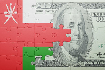 puzzle with the national flag of oman and dollar banknote