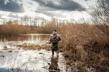 Fotobehang Jacht jager man kruipen in het moeras tijdens de jachtperiode