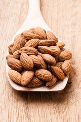 Almonds on wooden spoon