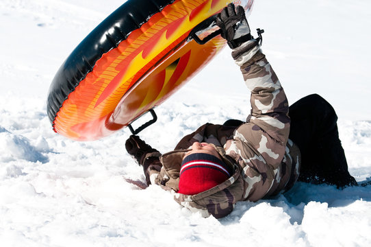 Young Boy Crashing On Tube In The Snow