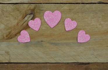 Sparkling glittering pink hearts set on pallet wood.  Valentine's Day, Wedding, Anniversary.  Romantic celebration, hearts are the symbol of Love.
