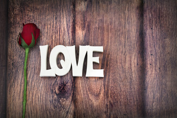 love and rose on wood table background