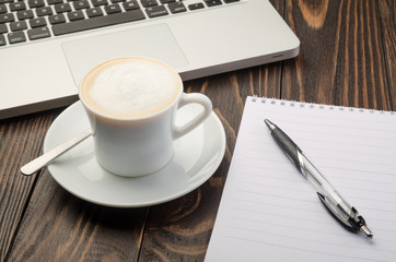 Cup Coffee, Computer and Note Pad on old wood background