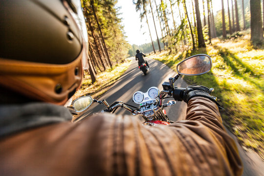Fototapeta Obsługuje siedzenie na motocyklu na lasowej drodze.