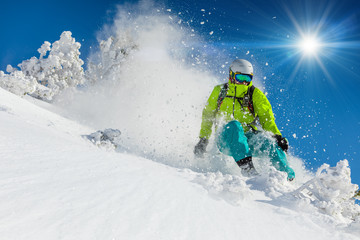 Skier skiing downhill in high mountains