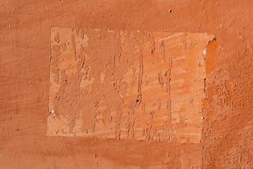 Traces of old announcements on terracotta wall. Background textu