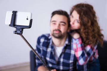 Fototapeta premium young couple taking photo with smart phone on selfie stick