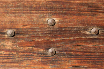 Old wooden gate fixed with rivets. Background texture
