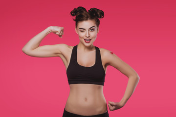 Fototapeta na wymiar Slender young woman doing fitness on a pink background