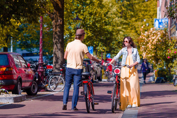 Happy family vacation on bikes in old streets in Amsterdam