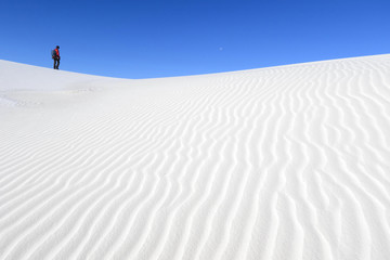 Photographer walking on white sand dunes, White Sands National Monument, New Mexico